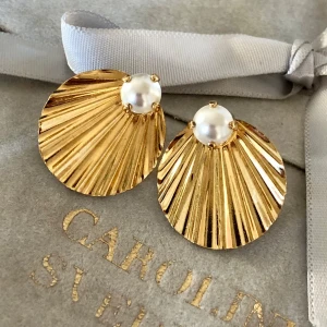 Caroline Svedbom stora örhängen  - Fina örhängen från Caroline Svedbom i guld med en pärla som dekoration Dem är i mkt fint skick och använt Max 3 gånger de är en större modell och passar bra för fest 