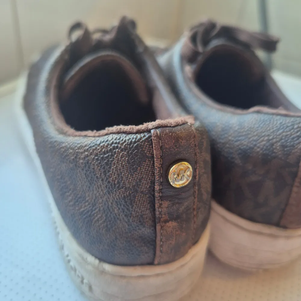 Säljer ett par bruna sneakers från Michael Kors i begagnat skick , dock så har ena märket lossnat på baksidan man kan säkert sy ihop från skräddare. Nypris 1600 säljer dom för 300. Skor.