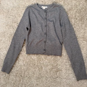 Grå kofta  - Fin grå kofta från Gina Tricot Young, i nyskick, oanvänd. Storlek 134-140 