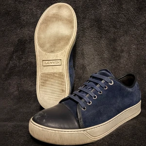 Blåa lanvin cap toe - Säljer ett par snygga blåa lanvin cap toe skor i storlek 42. Skorna är i helt okej skick med fåtal defekter som visas på bilderna. Snörerna är även smutsiga. Med lite sko behandling så kan man fixa till skorna. Hör av dig vid funderingar👍