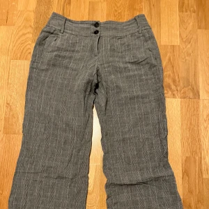 Grå rutiga kostymbyxor - Säljer ett par kostymbyxor i tunt material, står ej vilken storlek, men midjemåttet är 37 cm