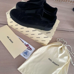 Axel Arigato skor, storlek 42 - Säljer ett par svarta sneakers från Axel Arigato i mocka. De är i bra skick och kommer med originalförpackning och dustbag. Skriv ett dm om du är intresserad!