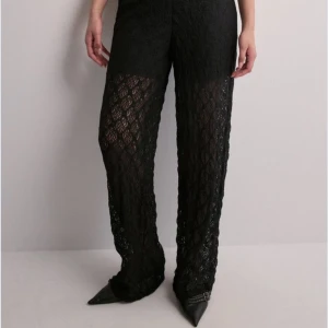 Svarta spetsbyxor - Snygga svarta byxor i spetsmaterial som ger en elegant och unik look. Perfekta för festliga tillfällen eller en utekväll. Byxorna har en loose passform. Aldrig använda. Nypris 550kr prislappen sitter kvar. 
