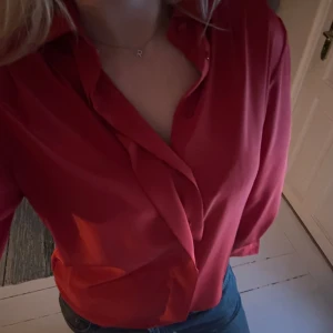 Röd blus - Snygg röd blus med långa ärmar och knappar. Perfekt för att ge en färgklick till din outfit. 
