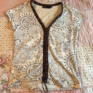 Mönstrad topp från KappAhl - Säljer en supersnygg mönstrad topp från KappAhl med svart och vit design. Den har en v-ringning och passar för er som kanske vill känna er lite mer som en yassifed cowboy 