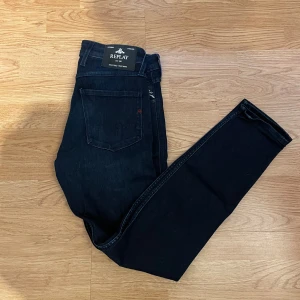 Mörkblå jeans från Replay - Snygga mörkblå jeans från Replay med en klassisk femficksdesign. De har en slim passform och är tillverkade i ett stretchigt denimtyg för extra komfort. Perfekta för en stilren look. Skriv om ni är intresserade eller har frågor!