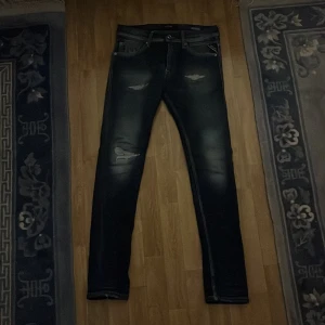 Blå jeans från Replay - Snygga blå jeans från Replay i modellen Jondrill. De har en cool slitningseffekt och klassisk femficksdesign. Storlek 28/30 passar bäst på dig som är på den smalare sidan