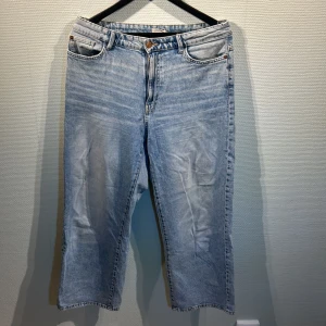 Ljusblå jeansbyxor - Säljer ett par ljusblå jeansbyxor med en klassisk femficksdesign. Byxorna har en rak passform och är perfekta för en avslappnad stil. De är tillverkade i ett slitstarkt denimtyg. 