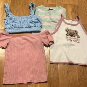 Fyra somriga toppar i olika stilar - Säljer fyra snygga toppar: en blå croppad topp med rynkade axelband, en mintgrön och rosa randig ärmlös topp från Zara, en rosa ribbad offshoulder-topp och en vit linne med rosa kanter och nallemotiv. Perfekta för sommardagar!