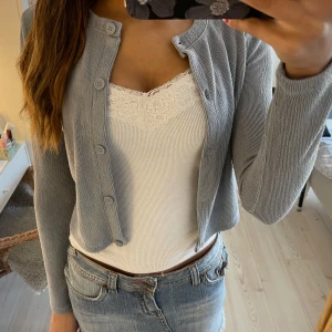 Grå kofta med knappar - Säljer en stilren grå kofta med knappar framtill. Koftan har långa ärmar och en ribbad struktur som ger en snygg look. Skriv om du har frågor! Pris kan diskuteras vid snabb affär!☺️