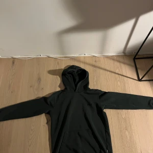 Grön hoodie från Mads Nørgaard - Säljer en stilren grön hoodie från Mads Nørgaard. Den har en klassisk design med en praktisk magficka och en bekväm huva. Perfekt för en avslappnad look.