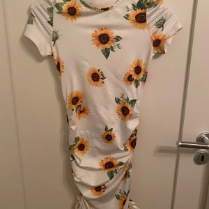 Vit klänning med solrosmönster från Shein - Säljer en söt vit klänning från Shein med ett härligt solrosmönster. Klänningen har korta ärmar och en bekväm passform, perfekt för sommarens varma dagar. 🌻