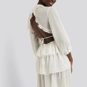 NA-KD strl 36 Studentklänning sommarklänning vit volanger - Fin vit klänning från NA-KD strl 36. Kanske di. studentklänning? Jättesöta volangdetaljer. Klänningen har långa ärmar och en öppen rygg med knytband. Jättefint skick! Se gärna mina övriga annonser för fler sommarkläder!