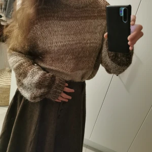 Brun och beige stickad tröja - Mysig stickad tröja i jordnära toner av brunt och beige. Tröjan har en avslappnad passform med långa ärmar och ribbade kanter. Perfekt för kyliga dagar. Oversized i storleken. Jag har normalt storlek 38/M. Måtten är: Längd:60cm, Armlängd:80cm, Bredd:50cm. 