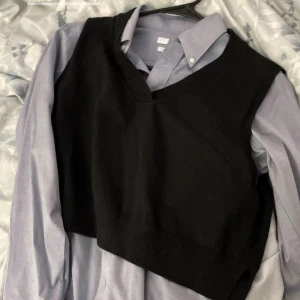 Svart väst - Snygg svart ribbad väst med v-ringning. Perfekt för lager-på-lager stil och passar till många olika outfits. Använd 1 gång, jättebra skick i strl XS