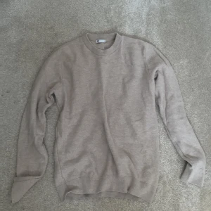 Beige stickad tröja från C - Säljer en stilren beige stickad tröja från märket C. Tröjan har en klassisk rund halsringning och långa ärmar. Perfekt för en avslappnad och bekväm stil. Passar bra till både jeans och chinos.