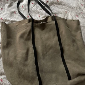 Mocka tote  - Beige mocka väska med mörk bruna läder band. Mjuk mocka som en tyg väska i formen. 