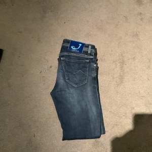 Mörkblå jeans från Jacob Cohen - Snygga mörkblå jeans från Jacob Cohen med klassisk femficksdesign. De har en knappgylf och stilrena sömmar som ger en tidlös look. Perfekta för en avslappnad stil.