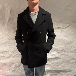 Svart skepparkavaj från Dondup - Säljer en riktigt fet svart skepparkavaj från Dondup med dubbelknäppning och klassisk krage. Perfekt för en stilren look. Tillverkad i Italien och passar bra till både jeans och mer uppklädda tillfällen. Den är aldrig använd och prislappen är nästan precis avtagen! Killen på bilden är 170cm!var nu inte rädd för att höra av dig vid frågor eller funderingar! Pris kan såklart som alltid diskuteras!😉🤩