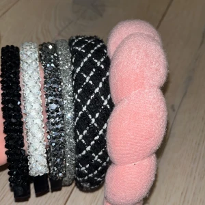 Flera diadem i olika stilar - Säljer ett set med flera diadem i olika stilar och färger. Inkluderar ett rosa vadderat diadem, ett svart och vitt rutigt diadem, samt flera glittriga diadem i svart och silver. Perfekt för att ge din outfit en extra touch!