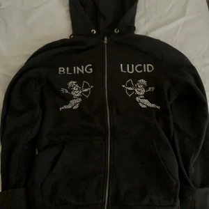 Svart bling lucid zip hoodie - Säljer nu en svart Bling Lucid zip hoodie. Har inte använt så mycket bara runt 3-4 gånger. Skick 9/10 som ny skulle jag säga, org pris runt 700kr och jag säljer den för 320kr, pris går att diskutera.