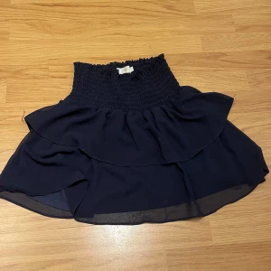 Mörkblå kjol från Chelsea - Säljer en superfin mörkblå kjol från Chelsea i storlek XS. Den har en elastisk midja och volangdetaljer som ger en söt och fladdrig look. Perfekt för både vardag och fest! 💙