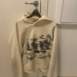 Vicinity x Lost Boys Hoodie - Säljer en beige hoodie från Lost Boys i mycket bra skick. Den har ett coolt tryck på framsidan med svart motiv. Perfekt för höst och vår, och den är superbekväm att ha på sig. Passar både till vardags och chillkvällar. 🖤