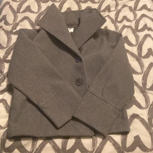 En grå kappa.  - Jag säljer min gråa kappa, som är ifrån Gina tricot då den blivit för liten för mig, den är i bra stick och använt den 1-2 gånger. 