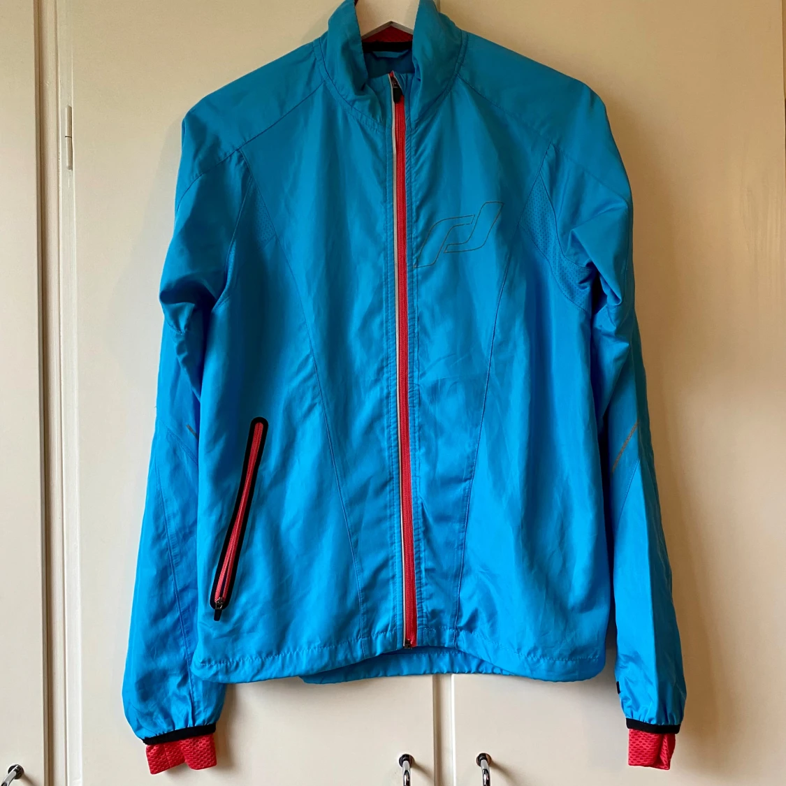 Blå löparjacka med rosa detaljer