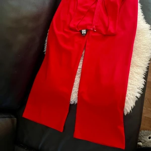 Röd elegant ärmlös jumpsuit – perfekt för fest! - Stilren långjumpsuit i rött med V-ringning och dragkedja bak. Bekväm, elegant och redo för fest eller utekväll! I stretchigt  material  och i utmärkt skick 