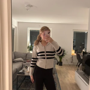 Beige och mörkblå randig stickad tröja  från Zara - Säljer en superfin beige hoodie från Zara med mörkblåa ränder. Den har en dragkedja framtill och är ribbad i materialet. Perfekt för både höst och vår! Den är i mycket bra skick💕