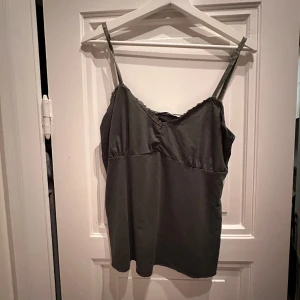 Grönt linne med spetsdetaljer - Gulligt grönt linne med sidenband och spetsdetaljer längs urringningen. Lite skrynklig pga legat i en påse på vinden. 