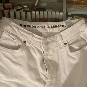 Vita jeans från Never Denim - Säljer ett par vita jeans från Never Denim i waist 26. De har en midwaist passform och är i modellen wide. Perfekta för en stilren look, oavsett om det är till vardags eller fest. 