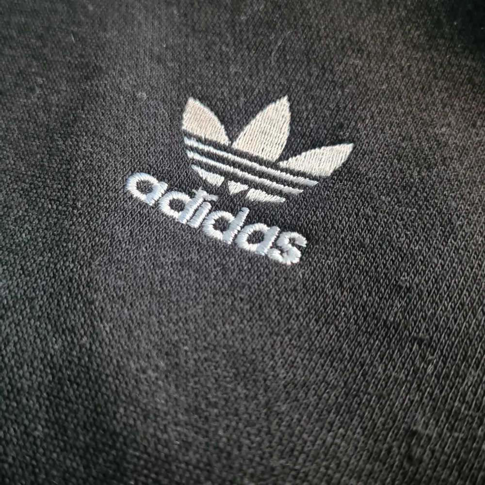 En svart hoodie från Adidas originals, helt oanvänd (nypris 500:-). Säljer pga felköp. Det är den klassiska designen. Storlek M/158. Skriv för fler frågor!. Hoodies.