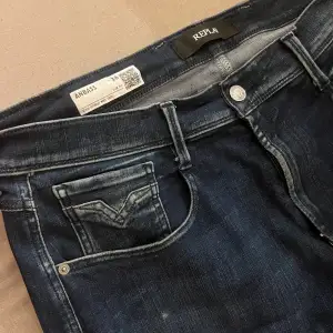 Säljer ett par snygga mörkblå Replay Anbass jeans i storlek herr 36. De har en klassisk femficksdesign och är tillverkade i ett stretchigt material för extra komfort. Perfekta för både vardag och fest! 🕺