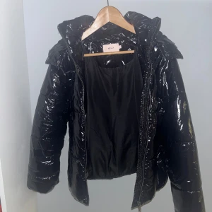 Svart glansig pufferjacka från Nelly - Säljer en svart glansig pufferjacka från Nelly i storlek S. Den är helt slutsåld och säljer den för att den inte kommer till användning💗