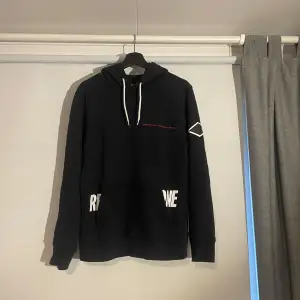 Säljer en snygg mörkblå hoodie från Replay med vit text på fickorna och huvan. Den har en klassisk passform med långa ärmar och en justerbar huva med vita snören. Perfekt för en avslappnad stil eller kyliga dagar.      Tveka inte att kontakta om du har frågor eller funderingar😁