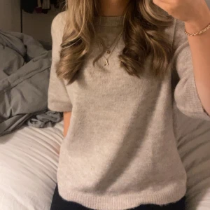 Stickad t-shirt - Säljer en sånhär stickad t-shirt i storleken xs( stor i storlek) den passar s. Den har ett skönt och mysigt material som är bekvämt att ha på sig i alla tillfällen. Färgen e lite rosa grå och tröjan passar perfekt till vardagen!❣️