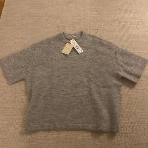 Stickad T-shirt  - Stickad T-shirt från Gina Tricot, premium collection. Storlek M med prislappen kvar.