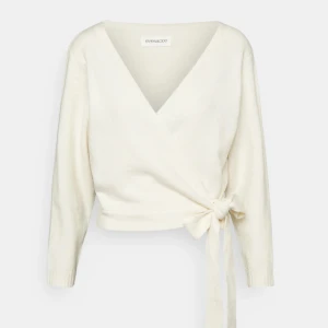 Vit omlottopp från EVEN AND ODD - Säljer en superfin vit omlottopp från EVEN AND ODD. Den har en v-ringad design och knytning i midjan som ger en snygg siluett. Perfekt för både vardag och fest! ❤️