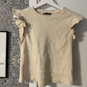 T-shirt med volang - Säljer min fina volang t-shirt från Zara som köptes för ungefär ett år sedan. Använd två gånger men inga tecken på användning.💛 Storlek M men passar S också! skriv gärna om ni har frågor!🫶🏽