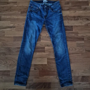 Blå jeans i storlek M - Säljer ett par klassiska blå jeans i storlek från lager 157. De har en snygg, sliten look och är perfekta för vardagsbruk. Jeansen har fem fickor och en dragkedja. De är i bra skick och redo för en ny ägare!