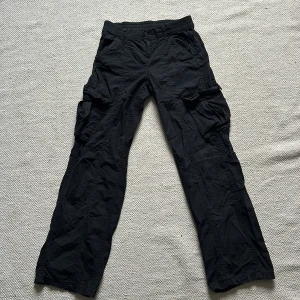 Svarta cargobyxor - Säljer ett par svarta cargobyxor i loose fit. Står ingen storlek i dem men tror det är 34. Bra skick, skriv för fler bilder eller frågor.