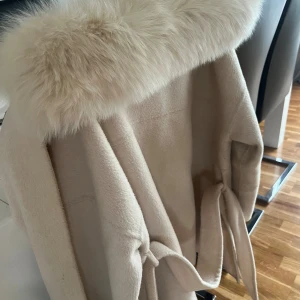Kappa med päls - Alicia coat off-white storlek M. Köpt från furstockholm, nypris 1600kr. Kappan har även äkta päls. Materialet på kappan är ull.