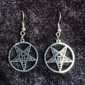 Nya örhängen m pentagram Baphomet Stål Ockult Wicca Metal Goth Satanic Punk - Silverfärgade runda örhängen med pentagram i form av Baphomet, ibland kallad bockguden från Mendez.  Längd ca 4,5 cm, bredd 2,3 cm. Krokar. Rostfritt stål. Lätta att bära. Tynger inte örat. Stilrena & ovanliga. Tåliga pga materialet. Bundlerabatt. 
