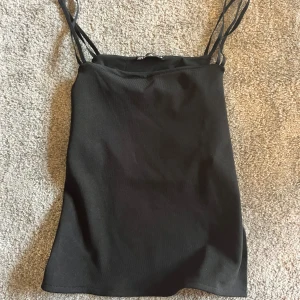 Svart Zara Party Topp - Jag ska sälja den här Zara toppen för den passar inte riktigt mig längre och har så många andra så rensar lite. Den är i storlek small och sitter as snyggt med en öppen rygg. Skriv om ni har fler frågor eller är intresserade!!🥰
