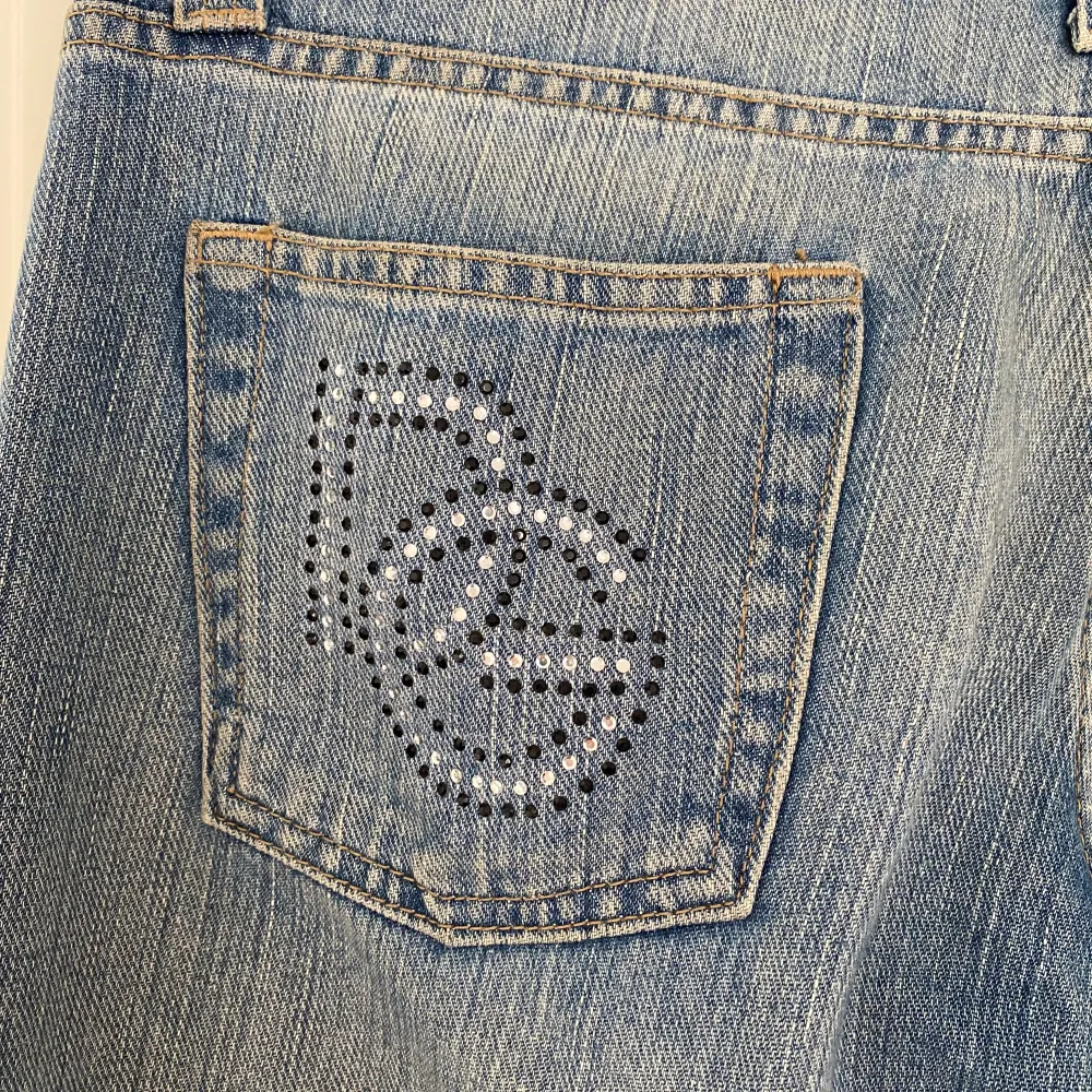 Mina älsklings Dolce & Gabbana jeans är nu till salu! Perfekt passform på mig som bär storlek 38, 177 cm lång. Lite utsvängda och lågmidjade. Vackra detaljer med glitter korn på både framsidan och baksidan, några slitningar på låren. Inga defekter ❤️‍🔥. Jeans & Byxor.