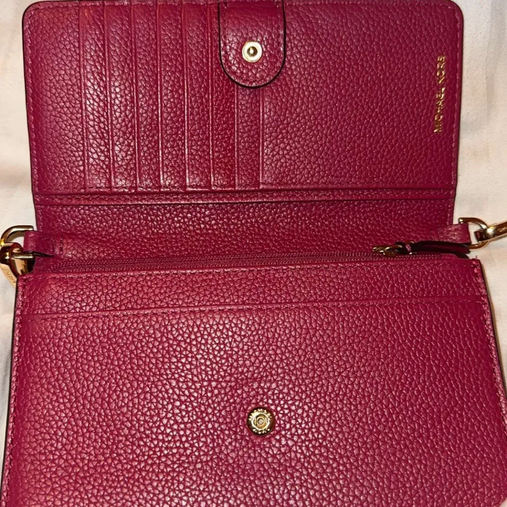 Snygg axelväska från Michael Kors i en kombination av brun och vinröd färg. Väskan har ett monogrammönster och är tillverkad i skinn. Använt 2 gånger och inte mer, den står i garderoben och tar ba massa plats. Laukut & Käsilaukut.