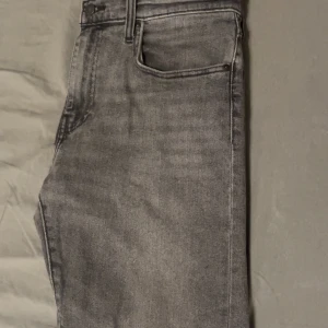 Grå jeans från Levi's - Snygga grå Levi's jeans i modell 502. De har en klassisk femficksdesign och en bekväm passform. Lite små i storleken annars perfekt. Det är bara att skriva vid fler frågor.