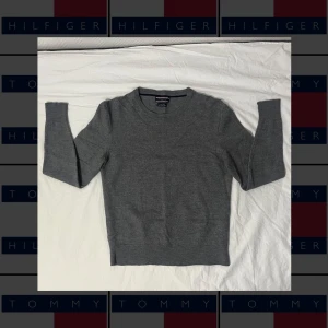Grå ulltröja från Tommy Hilfiger - En långärmad grå tröja från Tommy hilfiger i bomull, som inte hann användas mycket alls. Efter en feltvätt från farsan så har den krympt till en storlek S. Förutom att den inte är i sin originella storlek så är den felfri. Mycket fin i materialet och utan några skavanker.